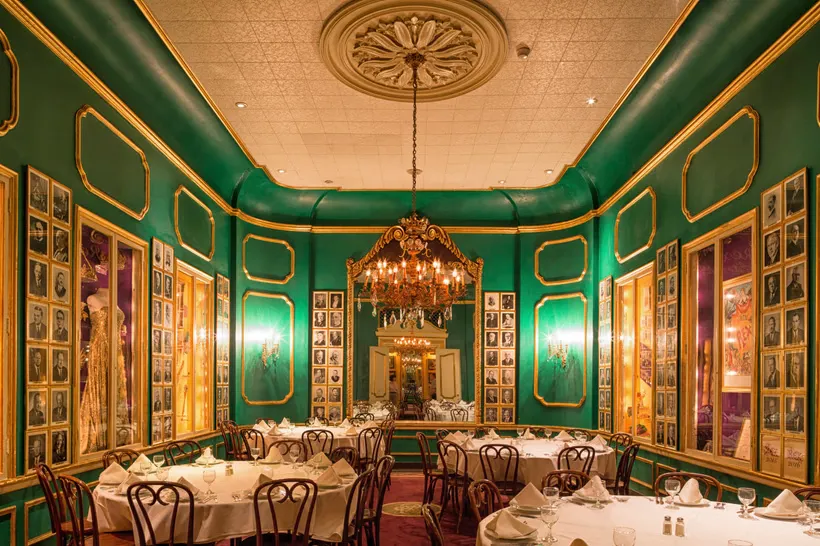 The green and gold dining room at Antoine's, set for dinner
